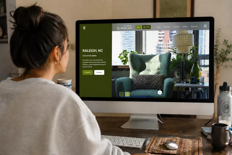 Woman viewing a Raleigh, NC apartment website on a desktop monitor